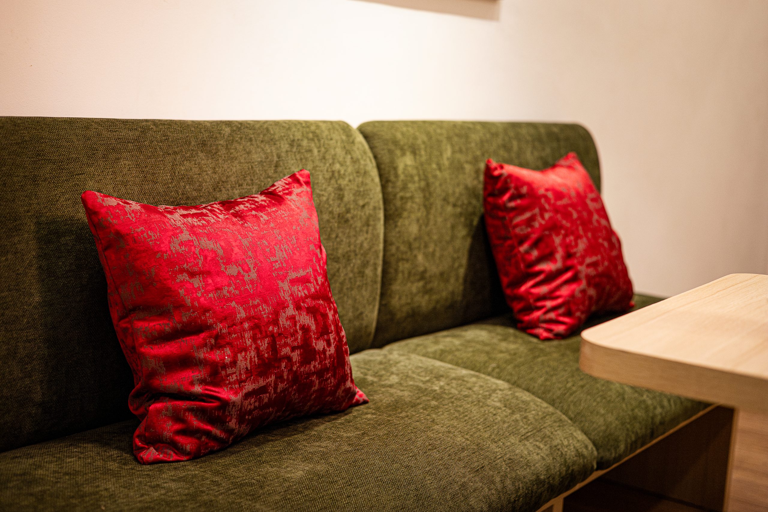 Chi tiết decor phòng khách với sofa và gối nhấn màu đỏ – ESPIO Studio